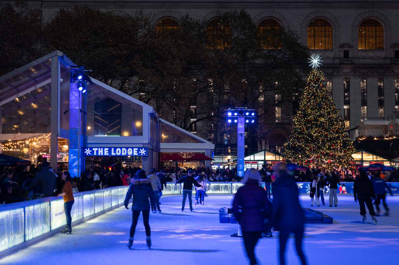 Bryant Park Christmas Tree viewed across ice skating rink with "The Lodge"