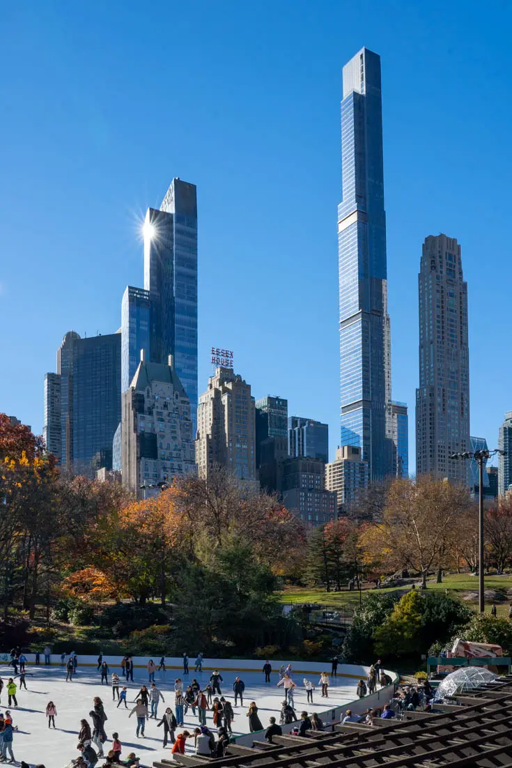 View of Manhattan skyscrapers from Central Park with Wollman Rink in the foreground