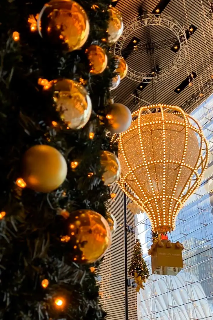 Golden hot air balloon with gold Christmas tree baubles in foregroung