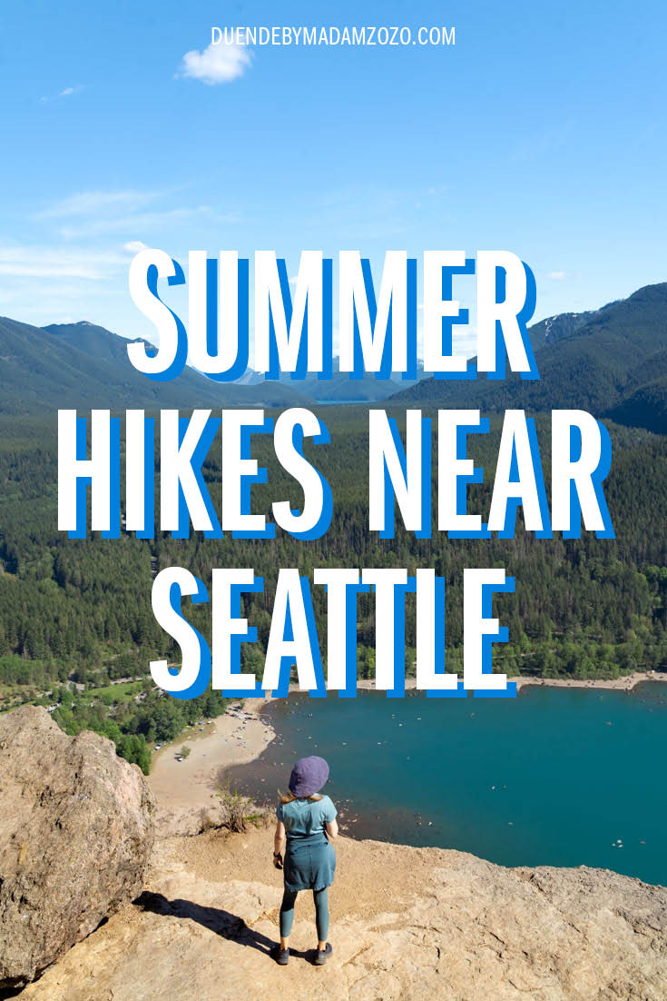 Super Summer Hikes Near Seattle Image of hiker looking out from rocky outcrop to lake and mountains with the title "Summer Hikes Near Seattle"