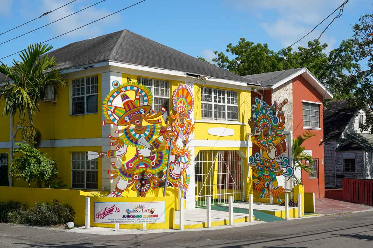 Yellow building with colourful cutouts of Junkanoo costumes out front