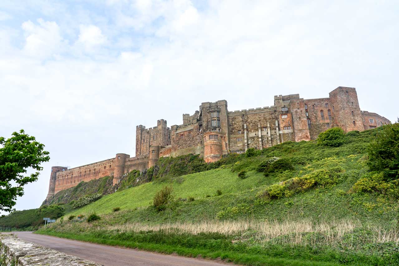 Large stone castle on top of grassy hill