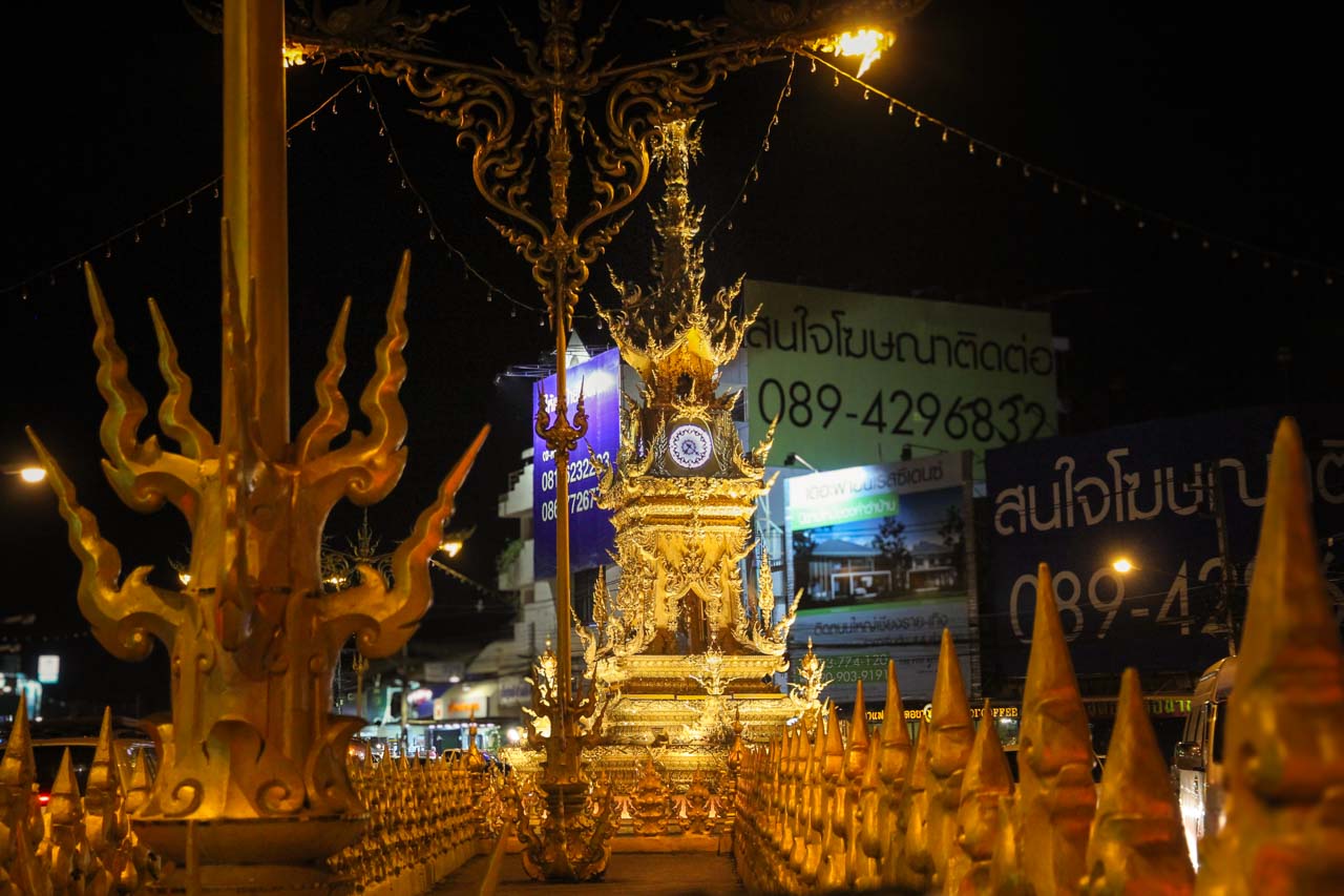 Ornate, golden, Chalermphrakiat Clock Tower illuminated at night