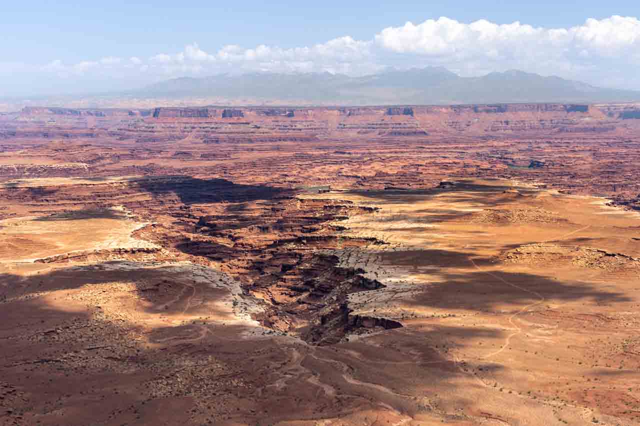 Overlook to desert canyon, with mountains in the distance