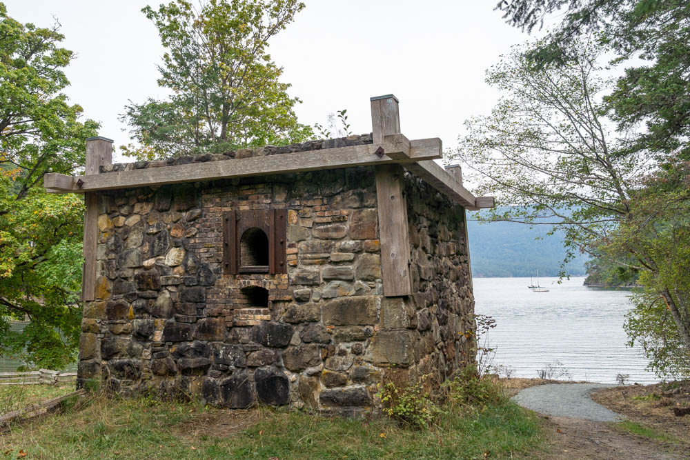 Historic stone structure with trees and water in background
