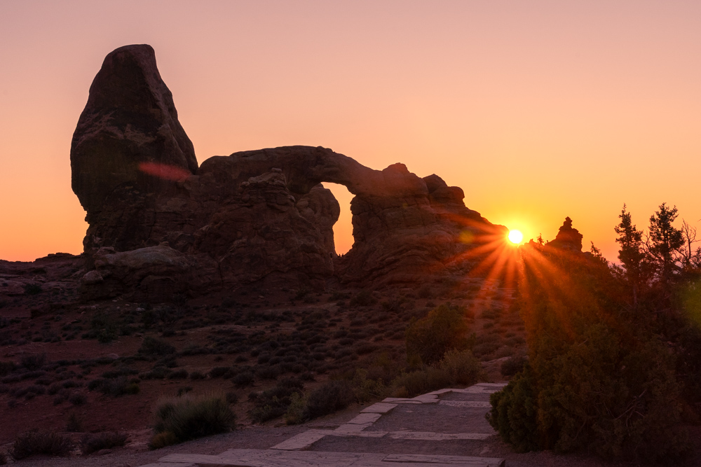 The sun setting behind Turret Arch