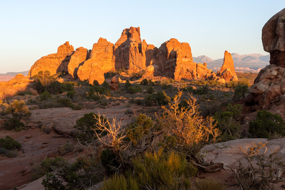 View to rock formation in distant, illuminated by golden hour light 