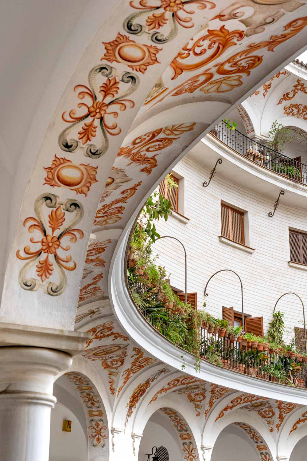 Curved building with handpainted details and garden-laden balconies