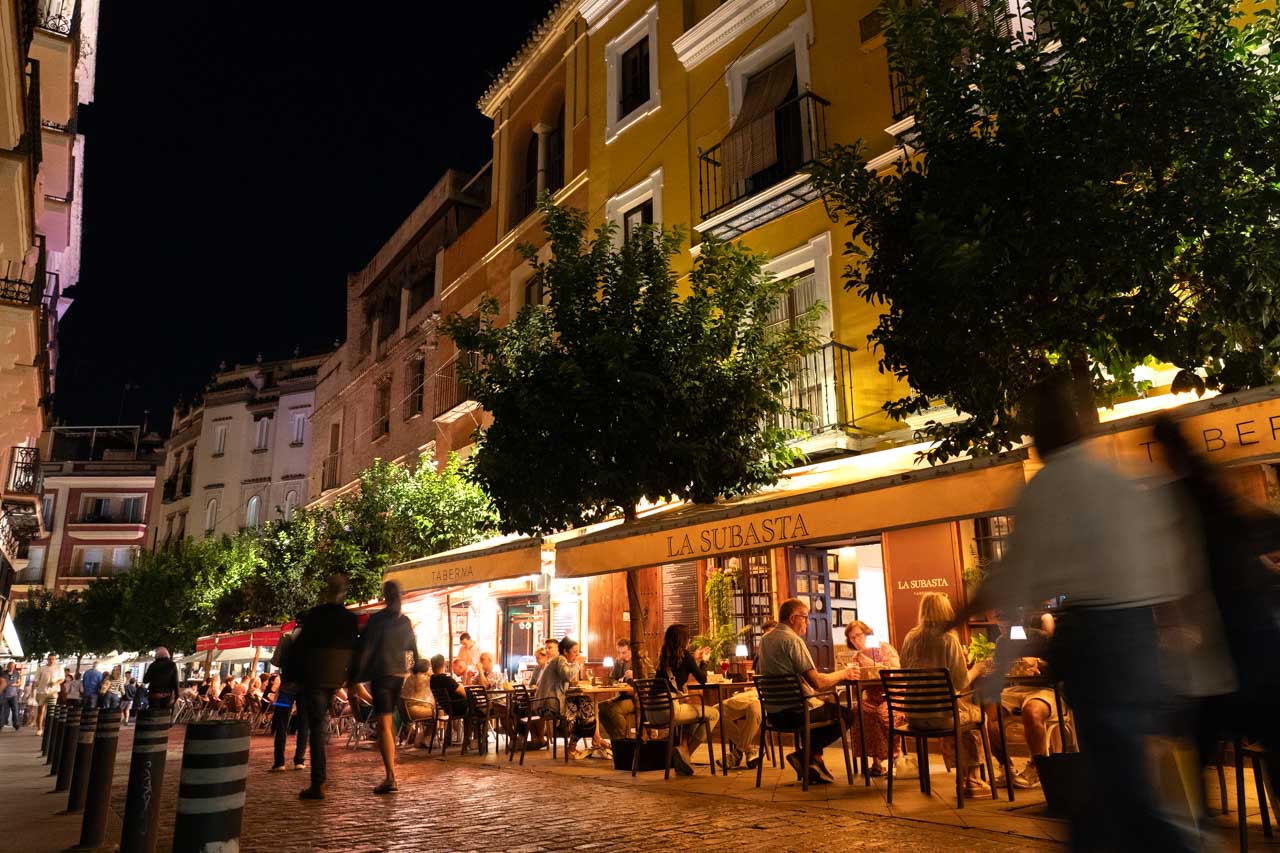 Image of diners outside illuminated restaurants at night