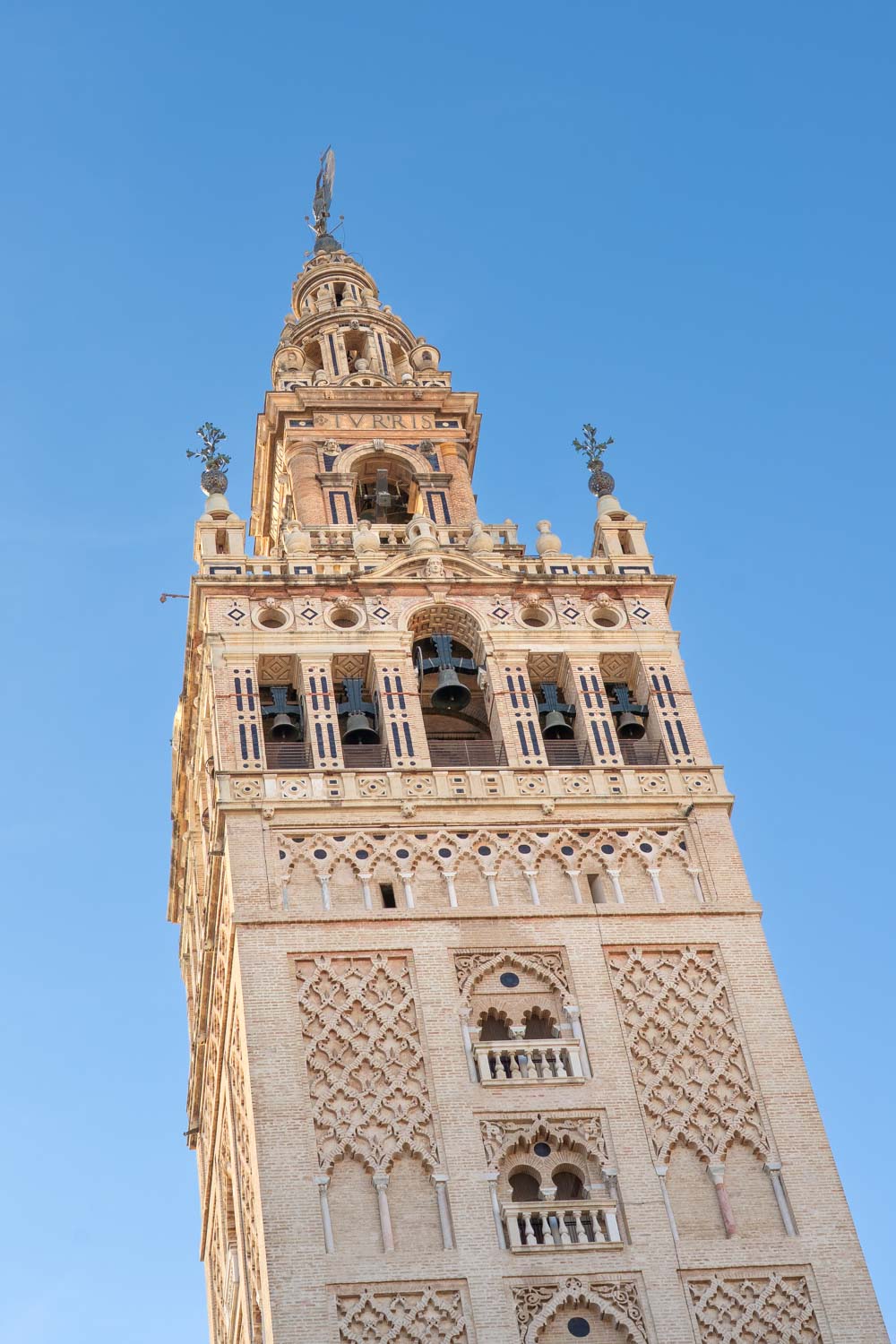 Bell tower of Seville Cathedral against blue sky