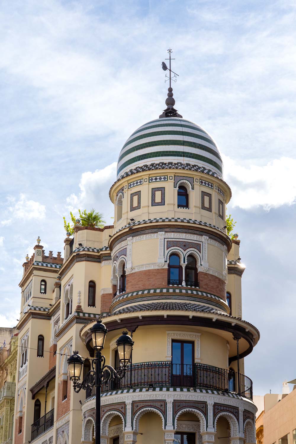 Neo-Mudéjar with striped dome against partly cloudy sky