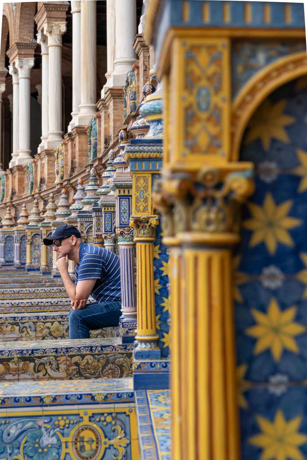 Man in blue looking out from blue and yellow tiled bays at Plaza de España