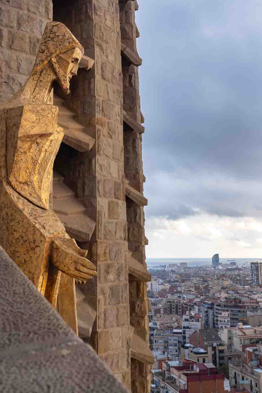 Image of Barcelona skyline on a stormy afternoon, with Christ sculpture on front on the Sagrada Familia in the foreground.