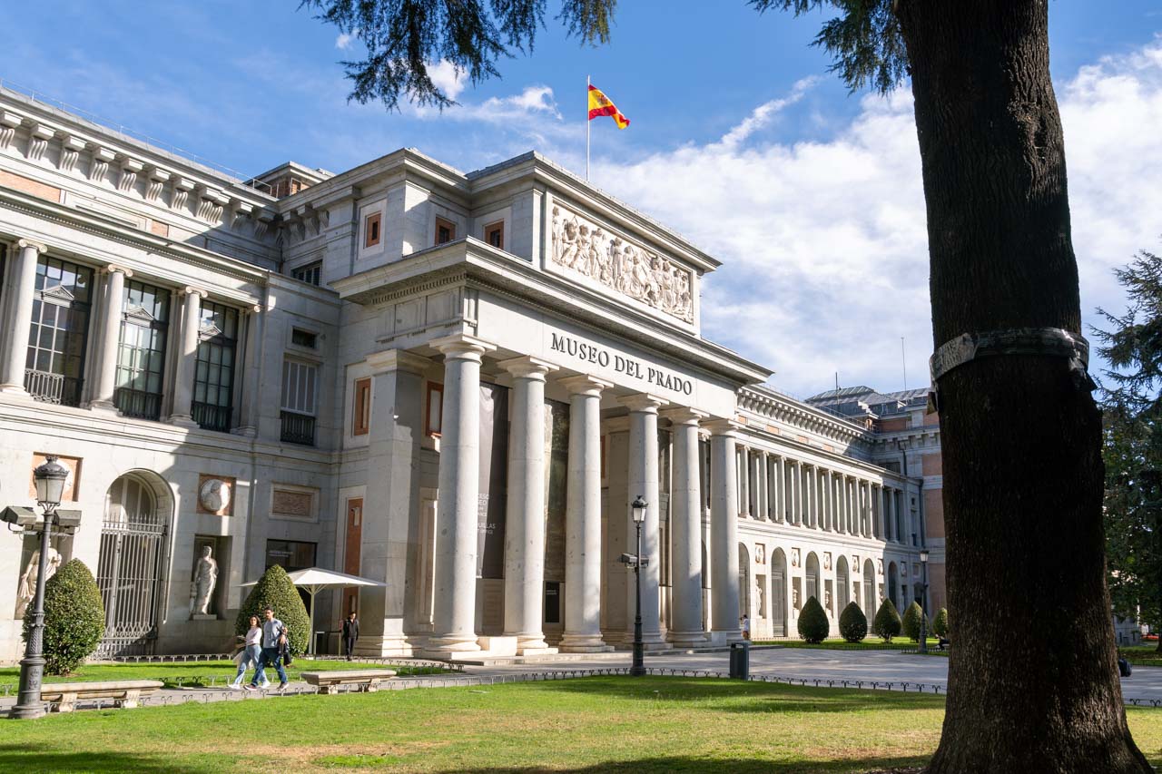 Exterior Neoclassical facade of Prado Museum with tree trunk in foreground