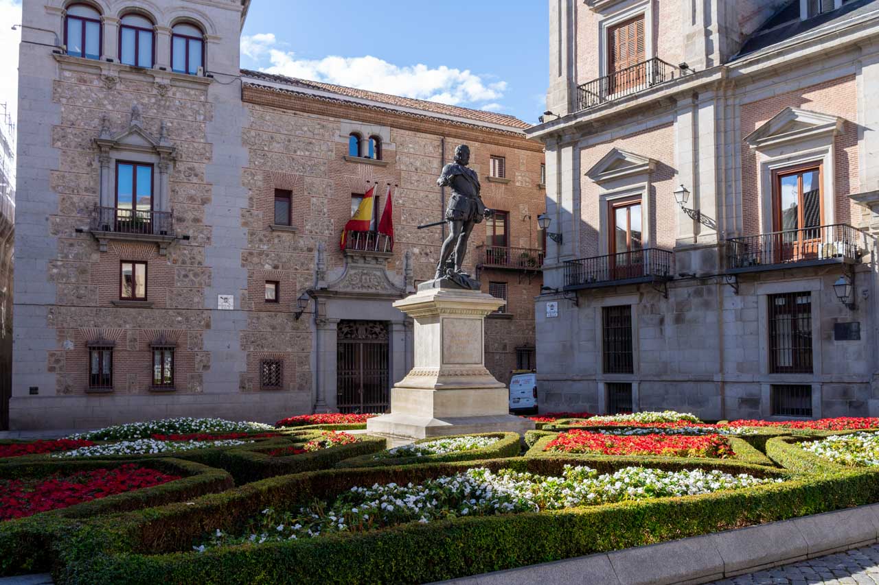 Historic plaza of Madrid with architecture representing various different centuries and a monument to Don Álvaro de Bazán
