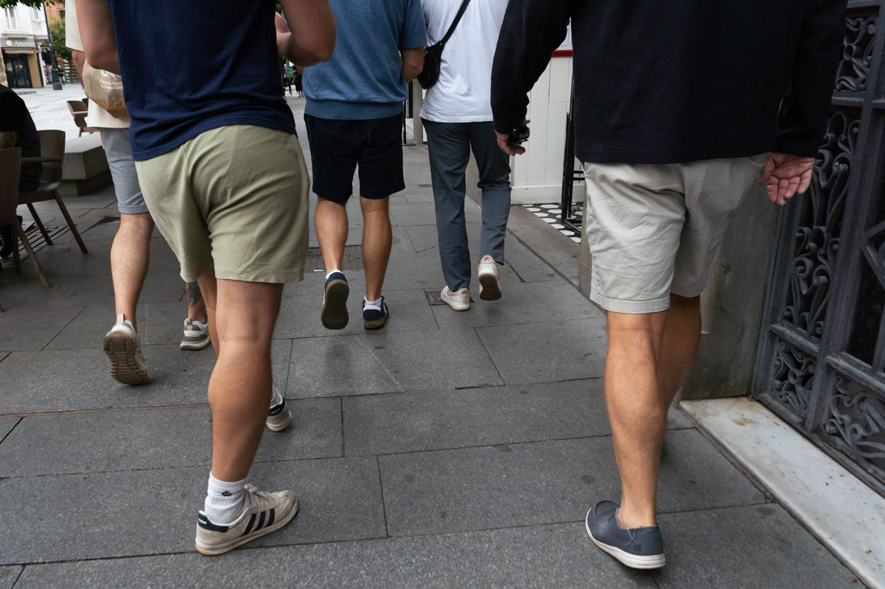 Photo of group of men from waist down, with four of them in shorts, and one in long pants
