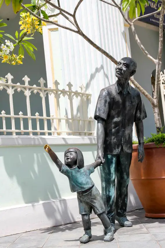Sculpture of grandfather and young granddaughter hand-in-hand