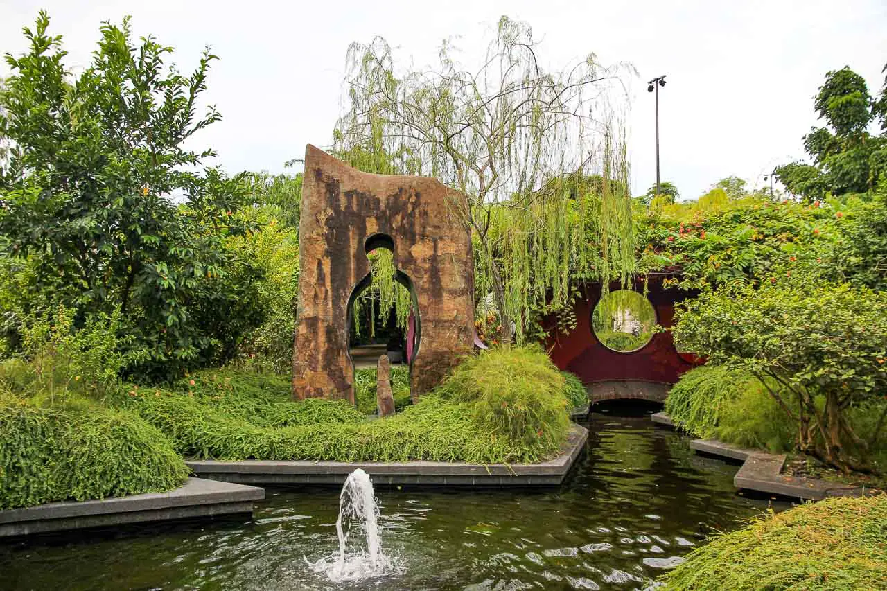 Sculpture by a pond in a lush garden