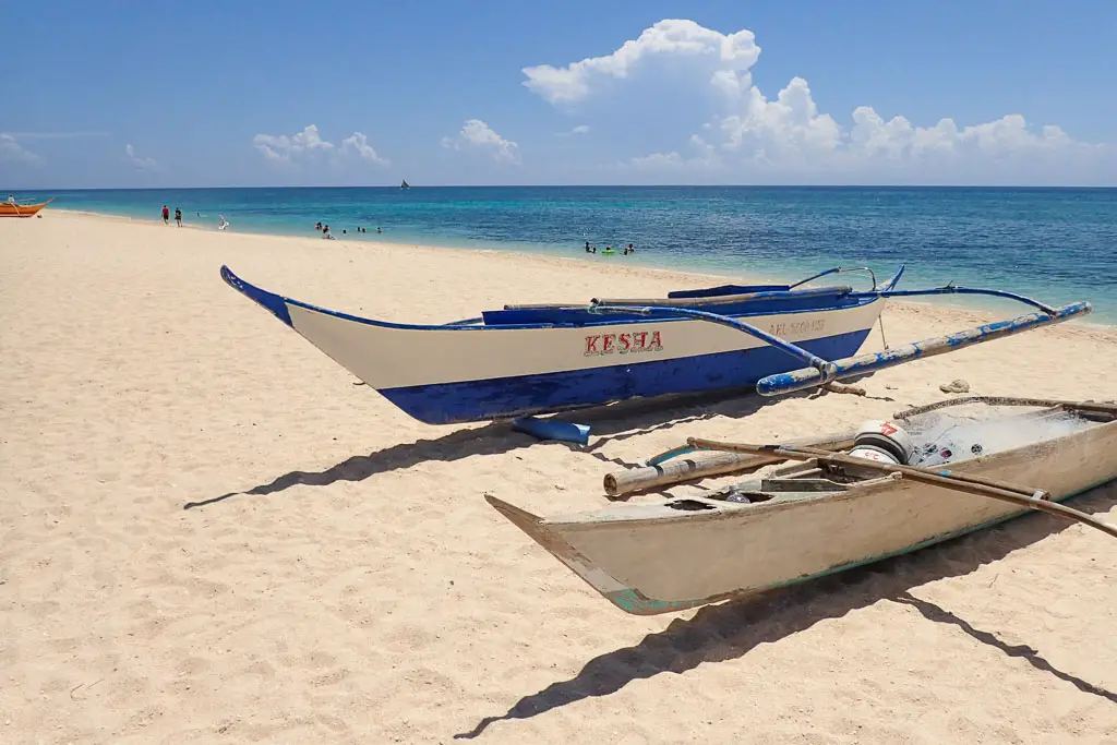 Two boats on the white sands of Puka Shell Beach
