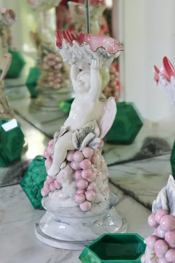 Porcelain statuette of child holding up pink sea shell