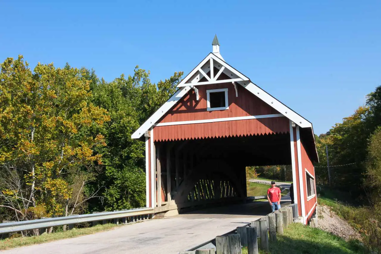 Wooden covered bridge in rusty red with white details