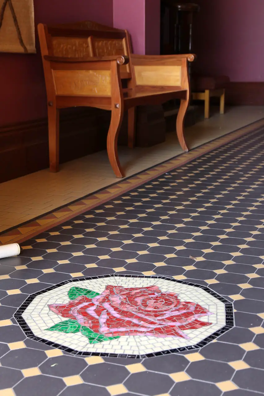 Tiled hallway with mosaic of red and pink rose