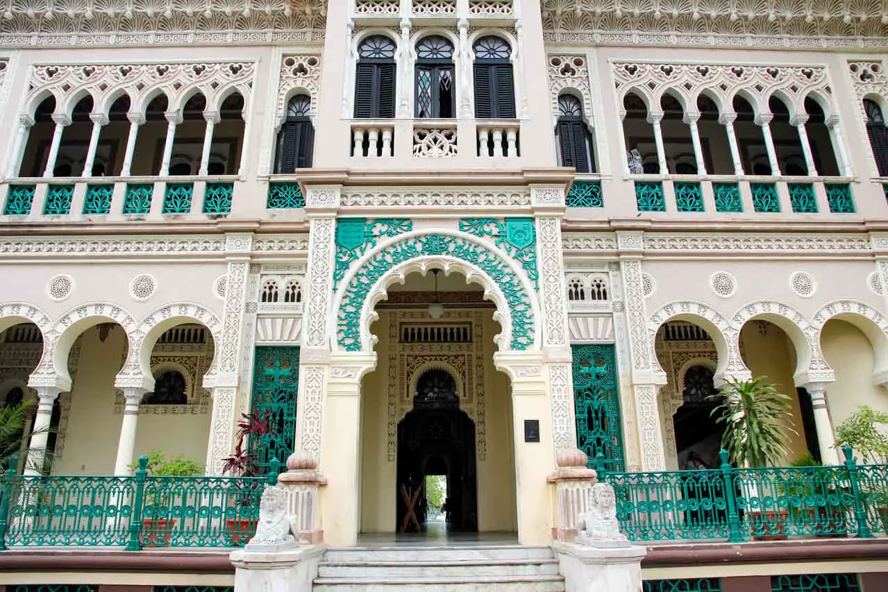 Looking up at the cream and green, Moorish-style facade of a two story building