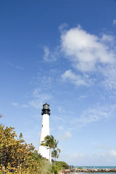 Black and white lighthouse against blue sky