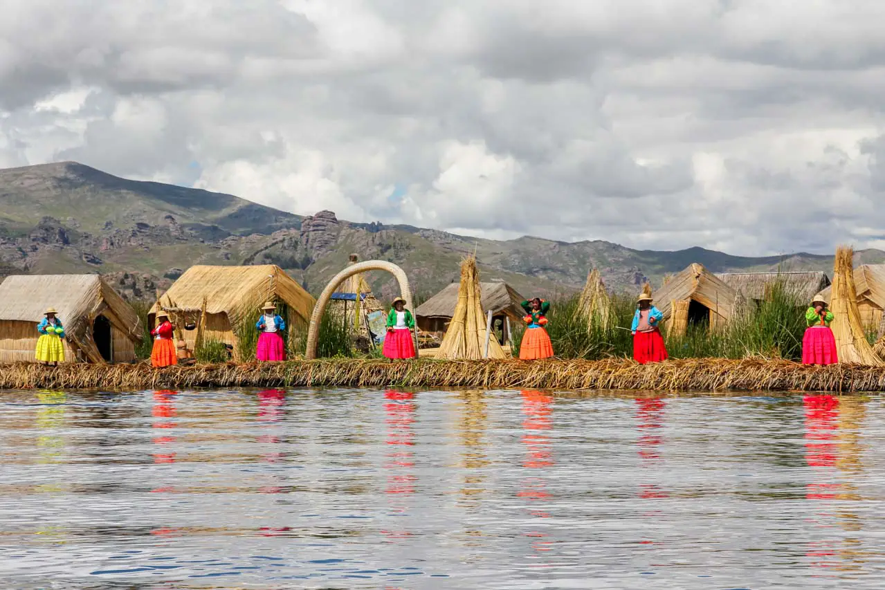 Floating reed island on Lake Titicaca with vividly dressed Uros women.