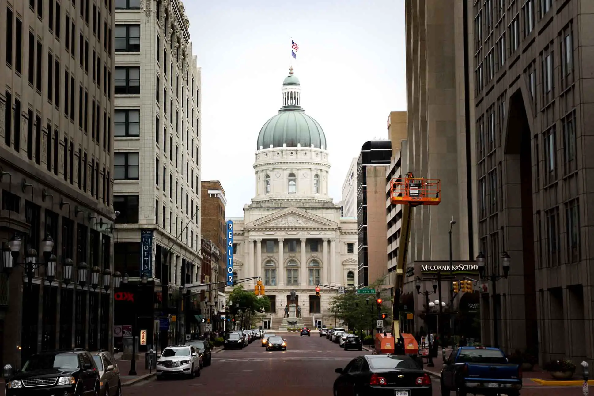 Indiana State Capitol viewed down city street, framed by buildings