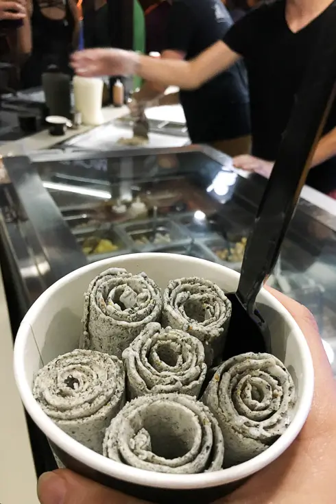 Rolled ice cram in paper cup with spoon
