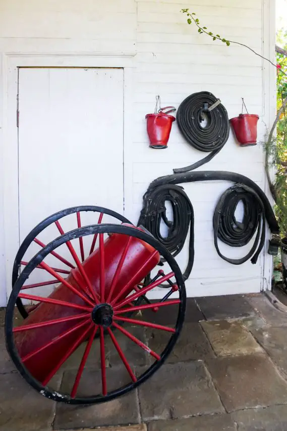 Photo of antique fire fighting equipment including hoses and buckets in red and black