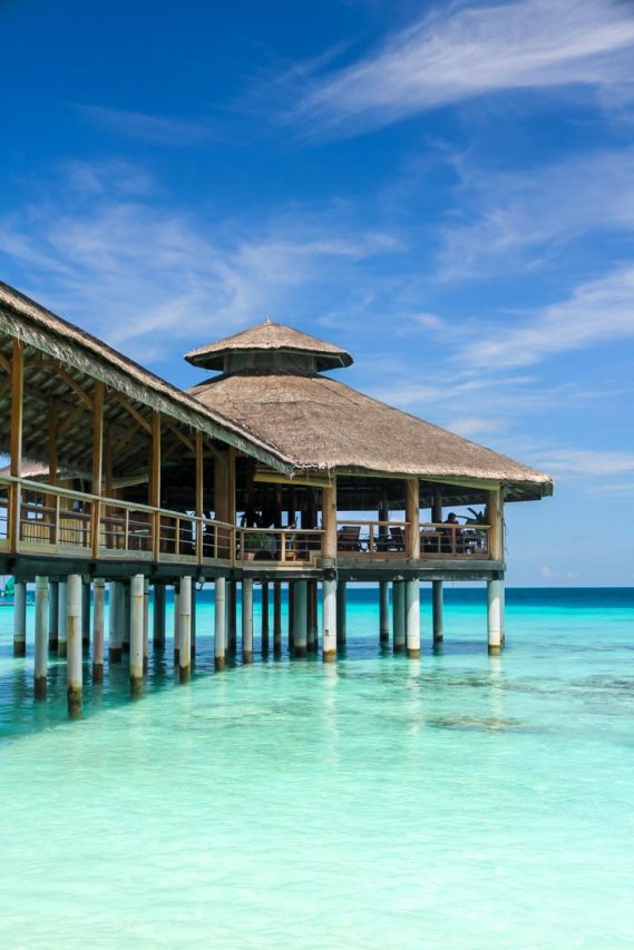 Overwater bar and restaurant with blue skies and turquoise waters