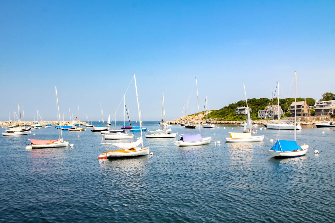 Photo of small sailboats moored in harbour with blue sky