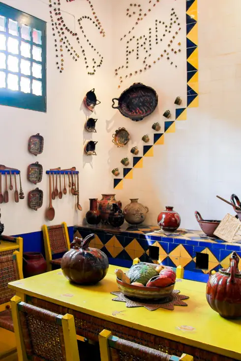 Yellow and blue adorned kitchen with "Frida" written on the wall