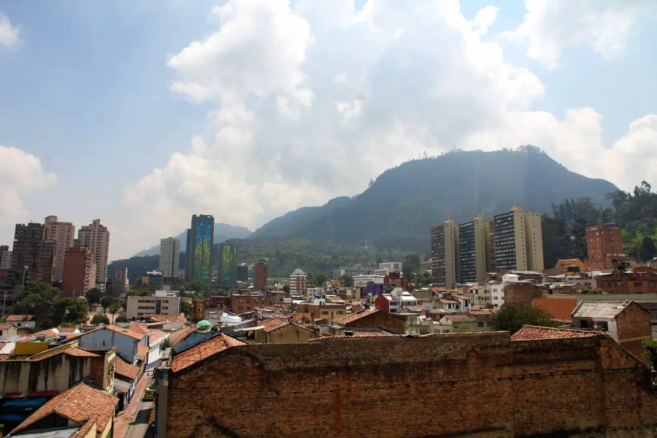 Mountain viewed over terracotta rooftops and highrise builidings