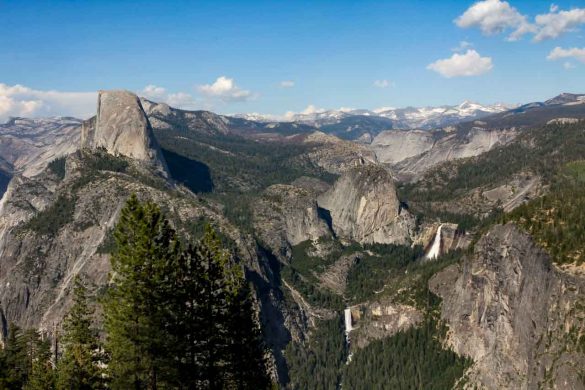 View across valley and snow capped mountains with two waterfalls and large geological features