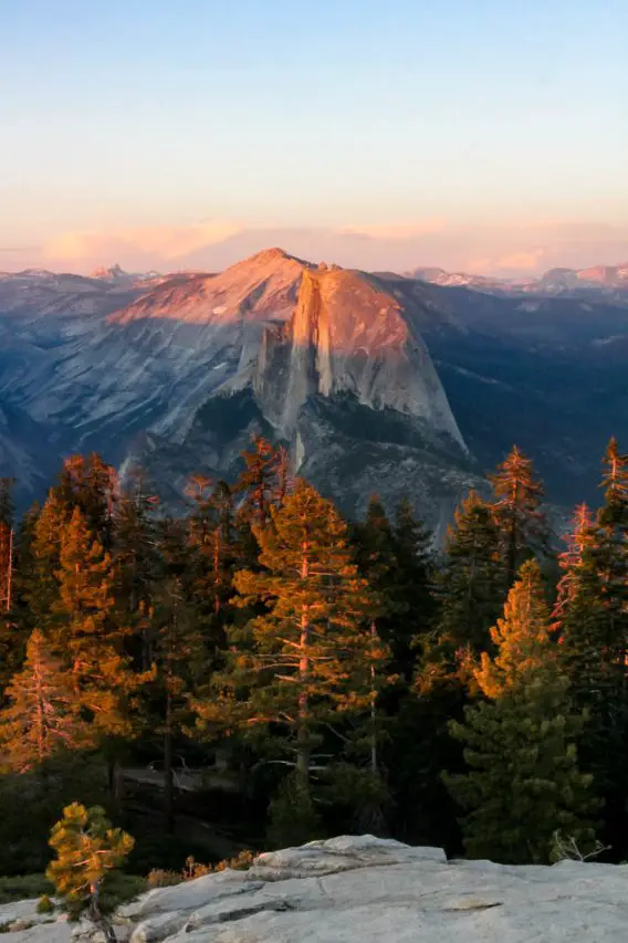 Half Dome viewed at Sunset across trees and valley