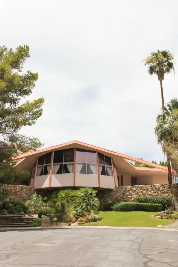 Front of mid-century home with lawn and palm trees