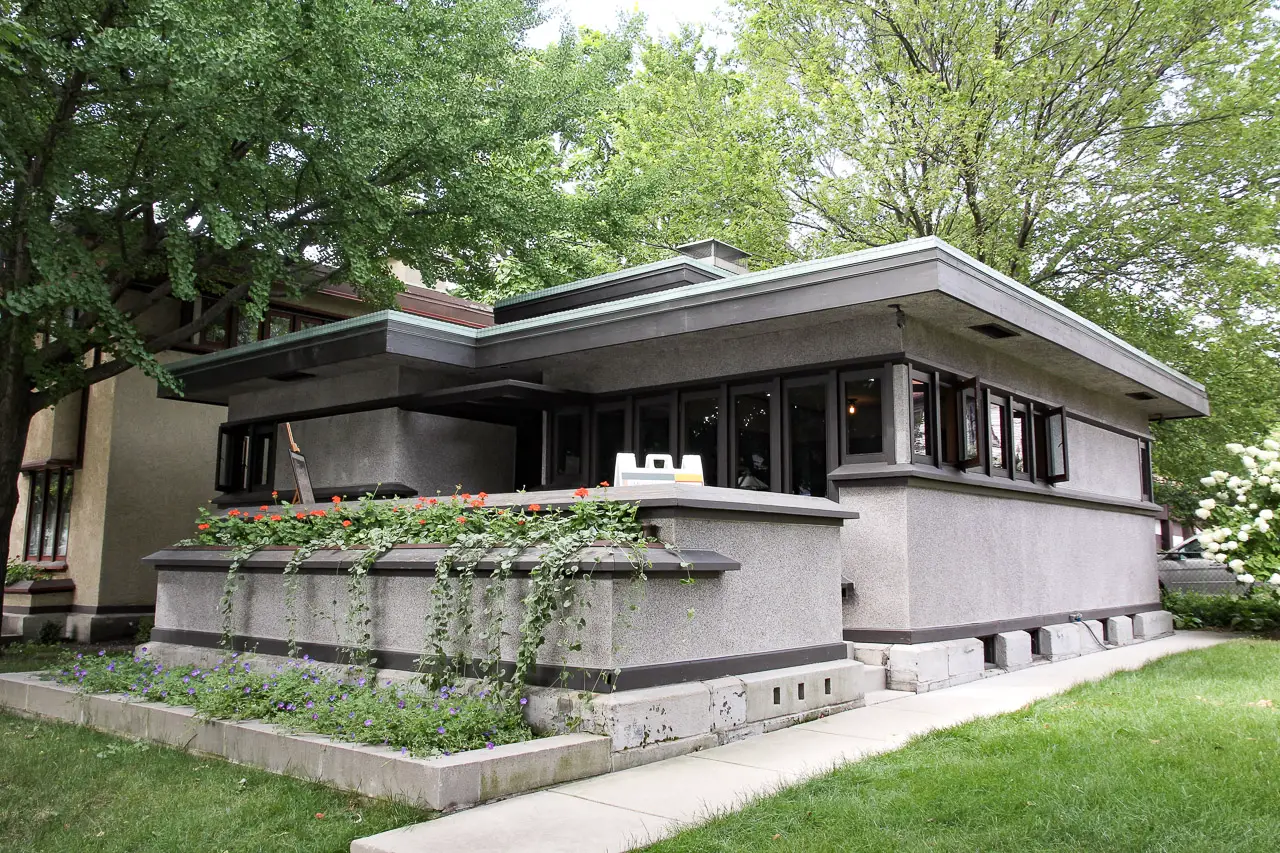 Grey, single story home with built-in planters on front porch designed by Frank Lloyd Wright
