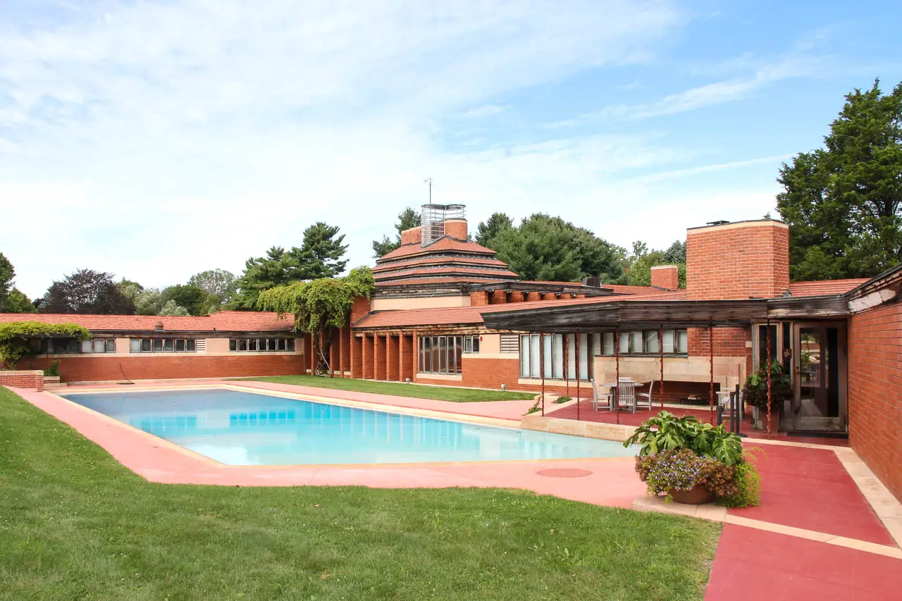 Image of large modernist brick home with pool in foreground