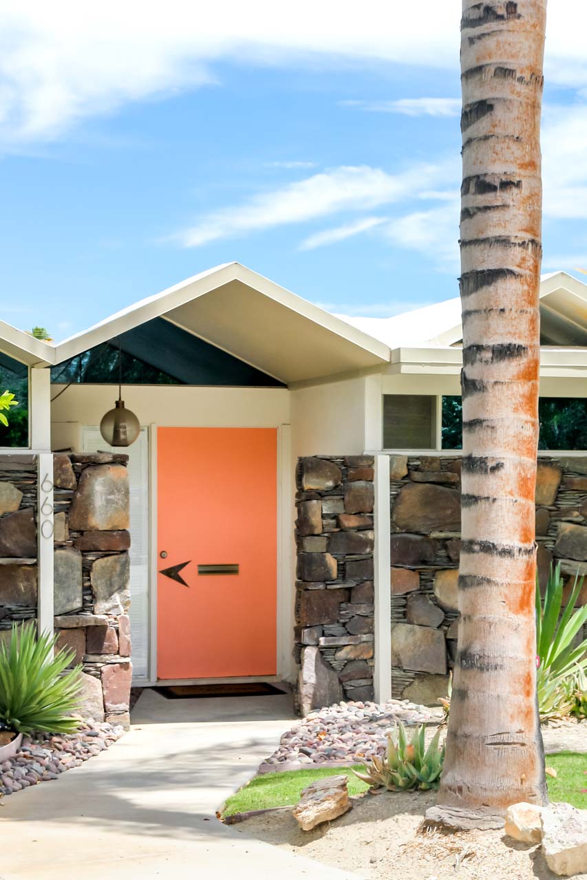 Peach door of condo with steel plate roof