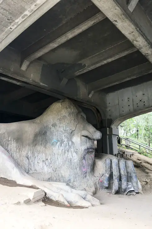Sculpture of troll holding VW Beetle, underneath a highway overpass