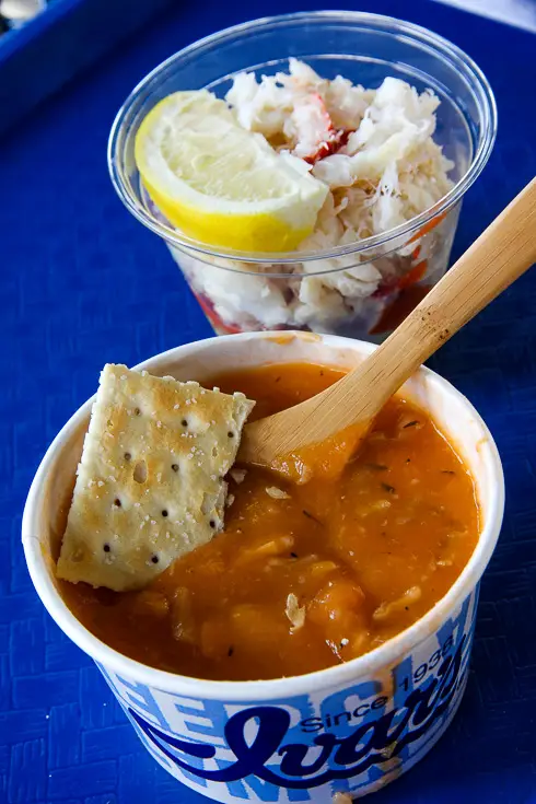 Red clam chowder and Dungeness crab cocktail on a blue tray