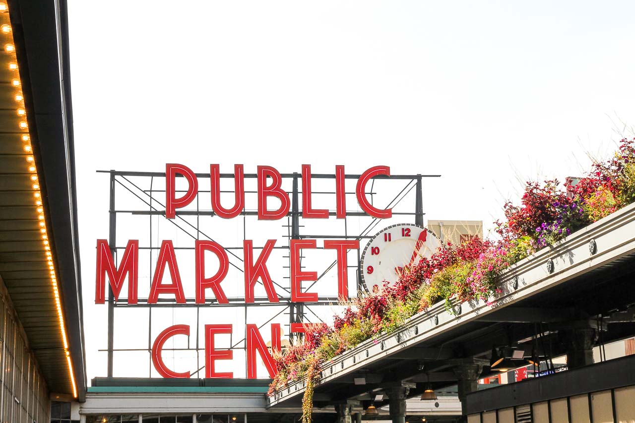 Sign with large red letters reading "Public Market Center" with rooftop garden in foreground