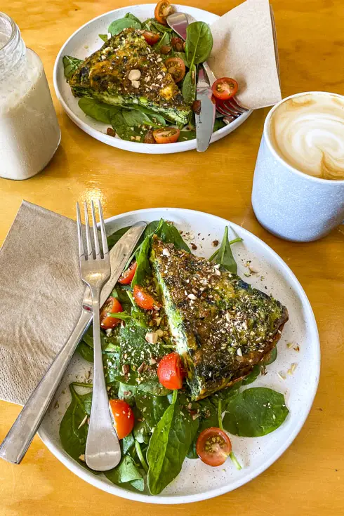 Plates of quiche and salad with coffee