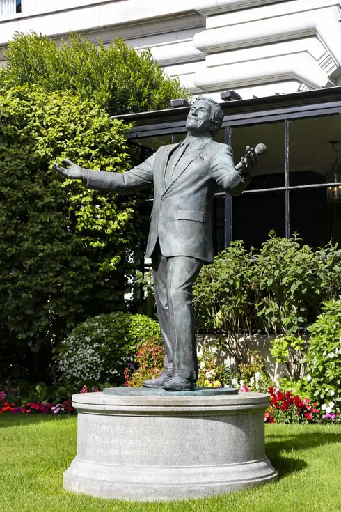 Statue of Tony Bennett with arms outstreched, holding a microphone