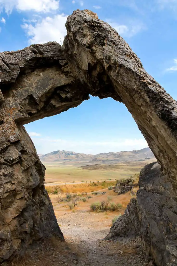 Photo of desert and arid mountains through a rock arch