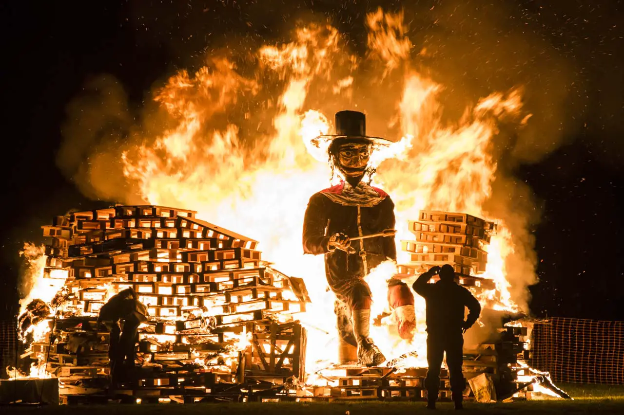 Man standing infront of Guy Fawkes bonfire