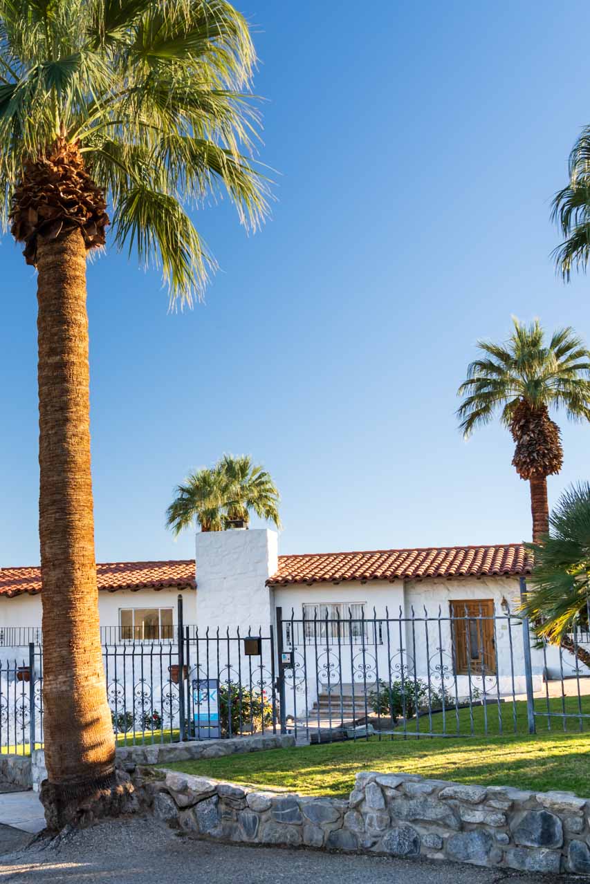 Spanish colonial home with palm trees in foreground